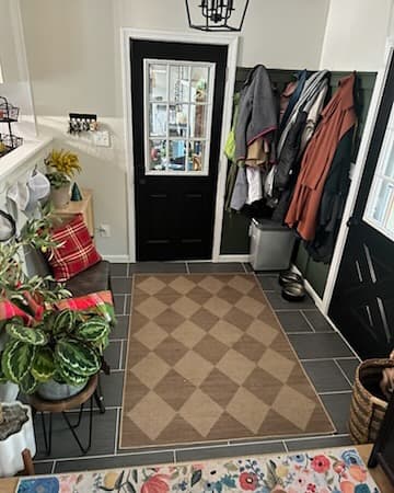 Mudroom entryway with coat hooks and black door