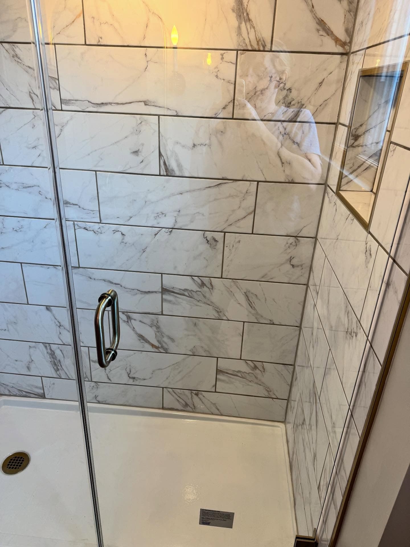 Bathroom vanity with arched gold mirror and marble counter