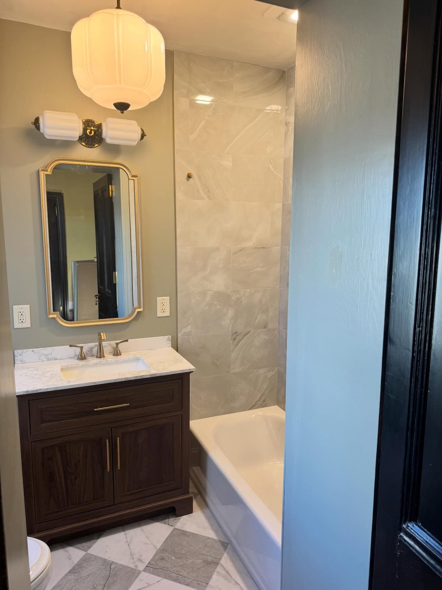Sage green bathroom with pendant light and checkered tile floor