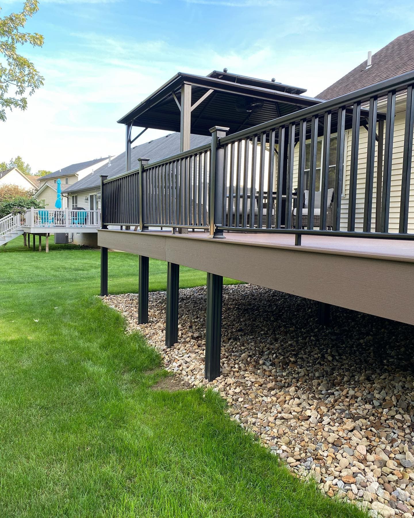 Composite deck with black railings and wood pergola
