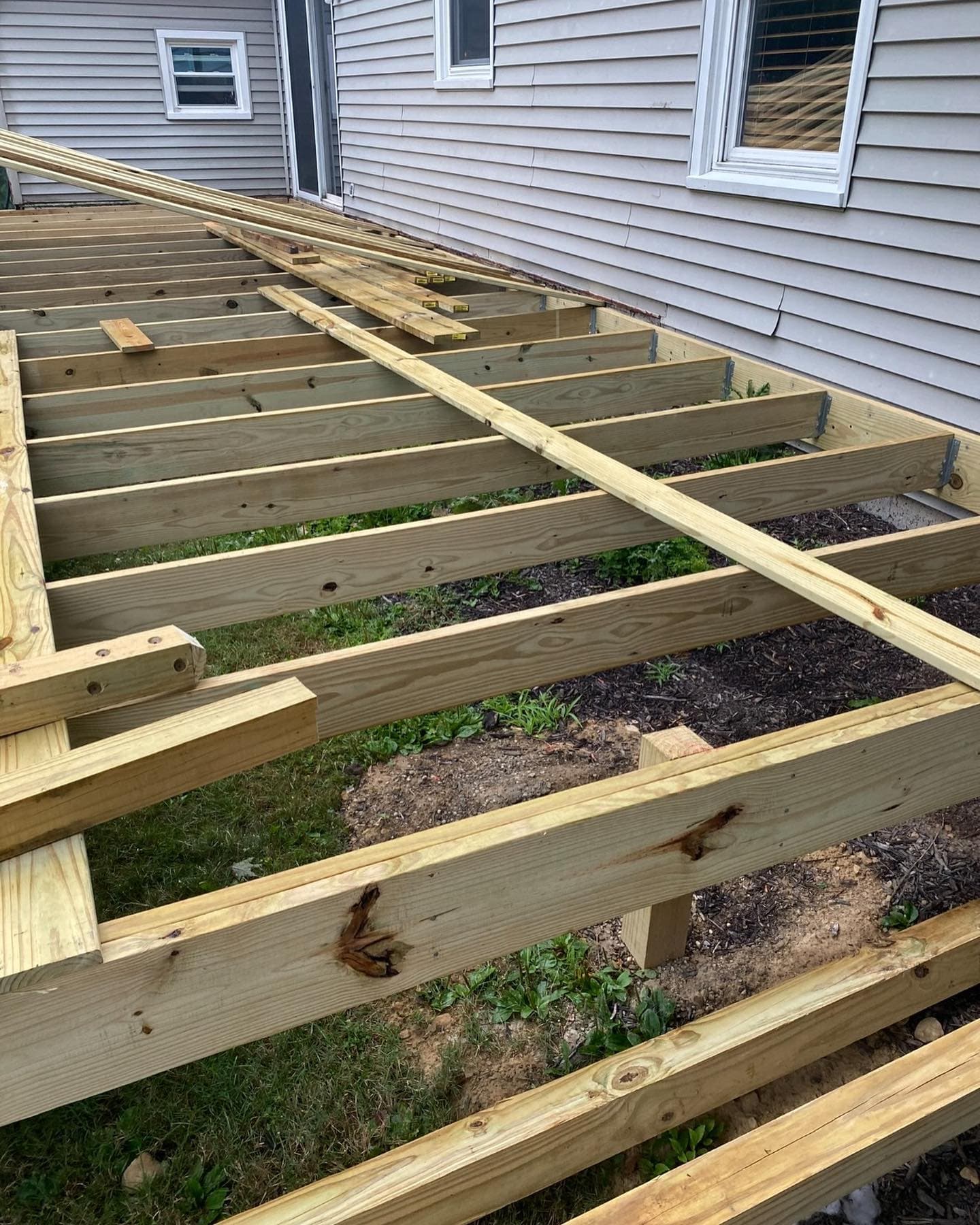 Deck joist framing against house siding