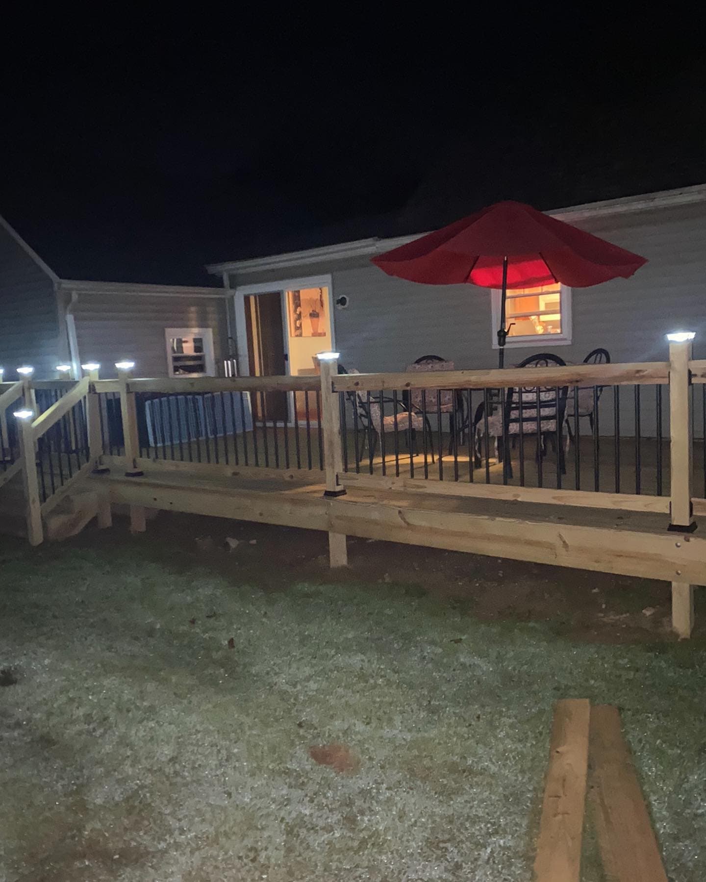 Finished deck at night with post cap lighting and patio furniture