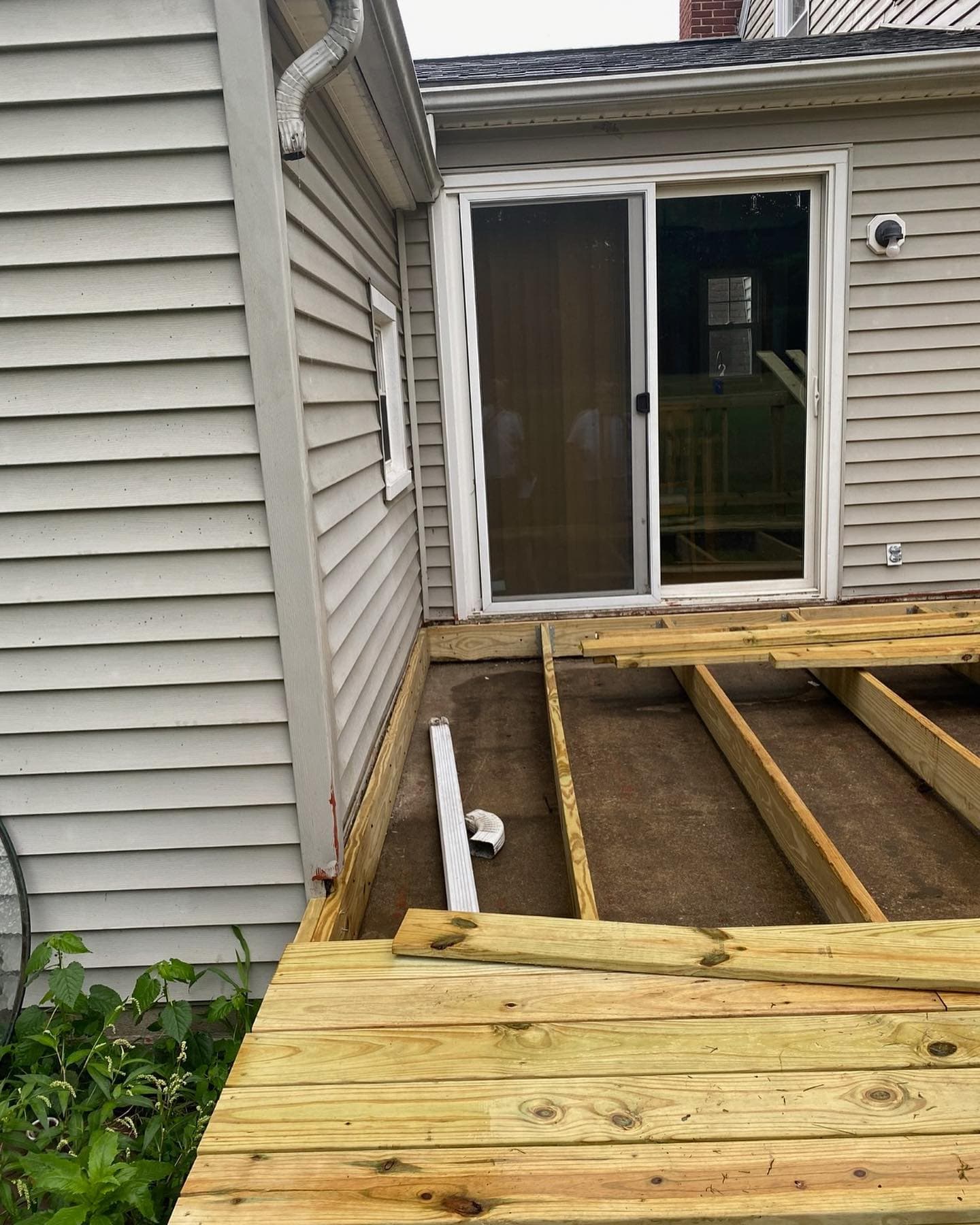 New deck framing attached to sliding door threshold