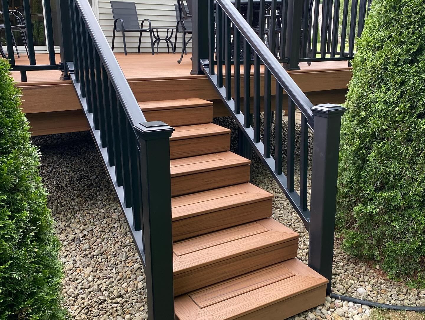 Deck stairs leading up to dining area under pergola