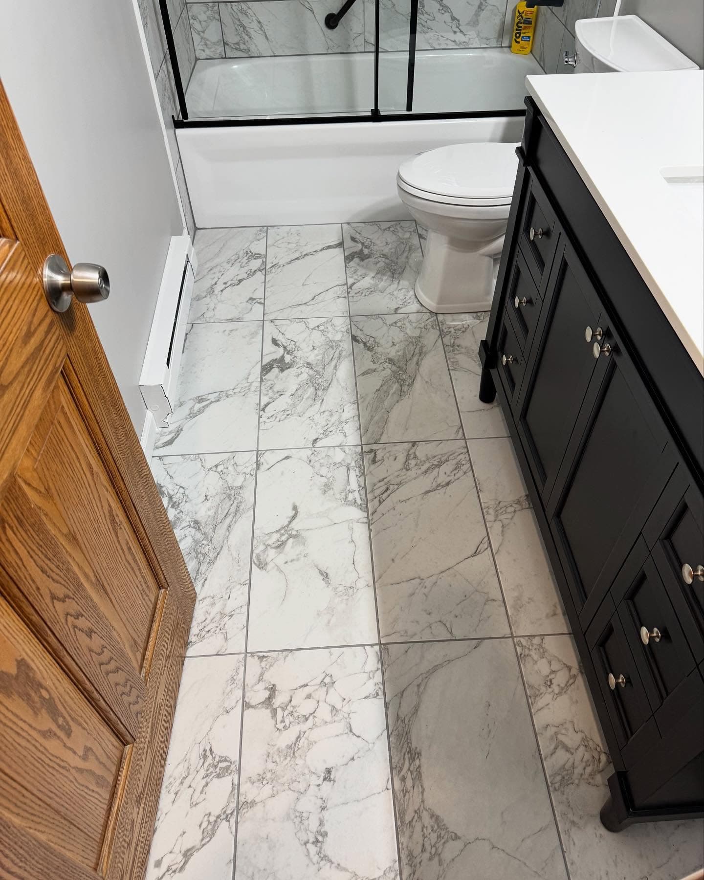 Marble tile floor with black vanity and toilet