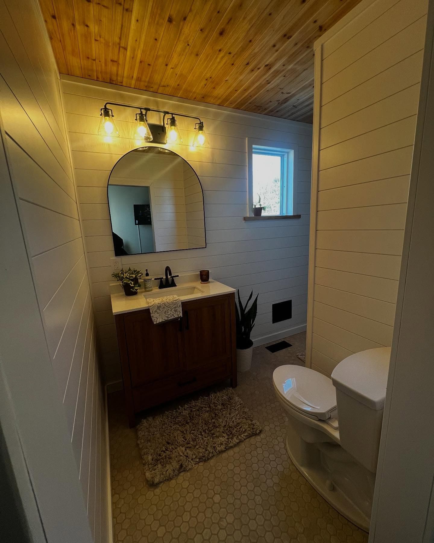 Dark wood vanity with gold leaf arched mirror