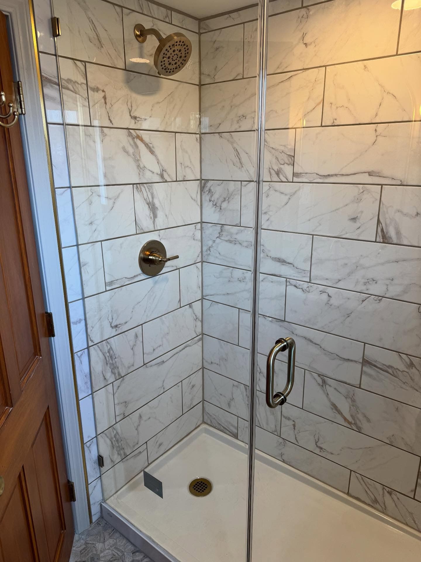 Marble subway tile shower with brass fixtures