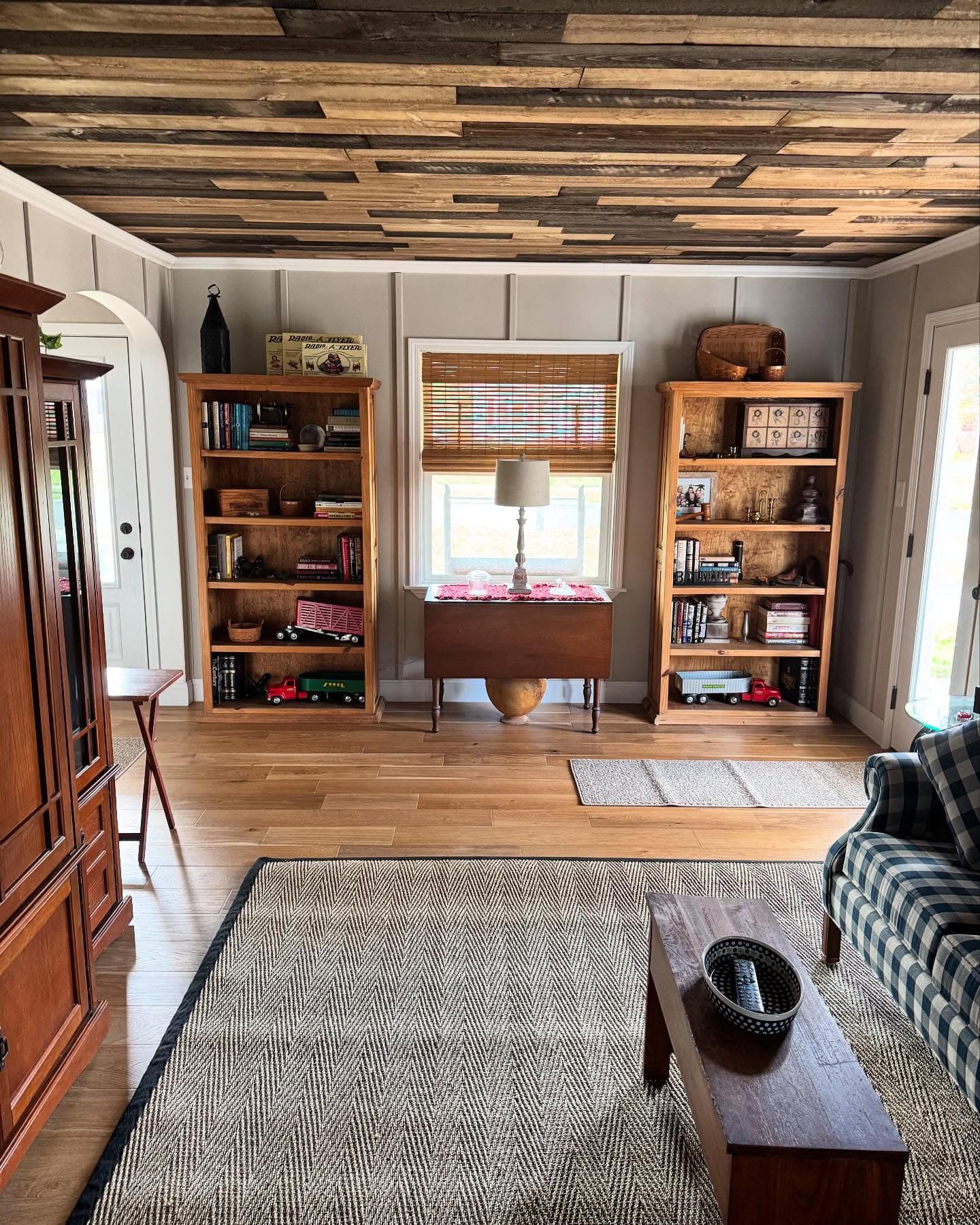 Living room with wood plank ceiling and built-in bookshelves